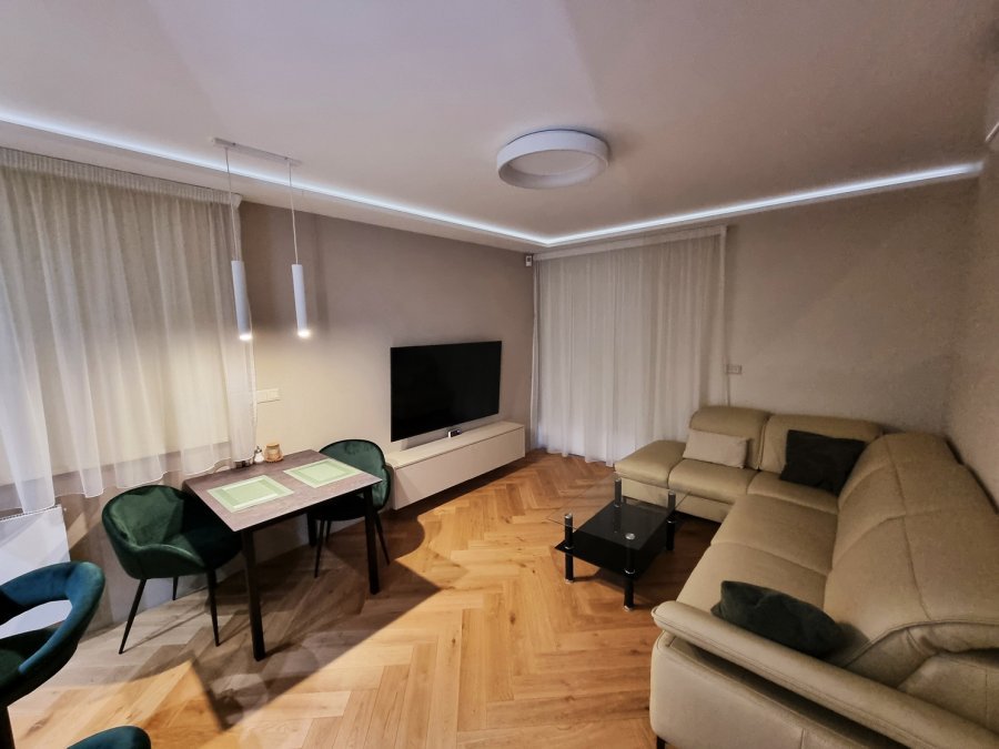 Večerní pohled na obývací pokoj s jemným stropním podsvícením, jídelním stolem a rohovou sedačkou | Realizace kuchyně a interiéru byt Svitavy, Hradec Králové | Pemtrade.cz