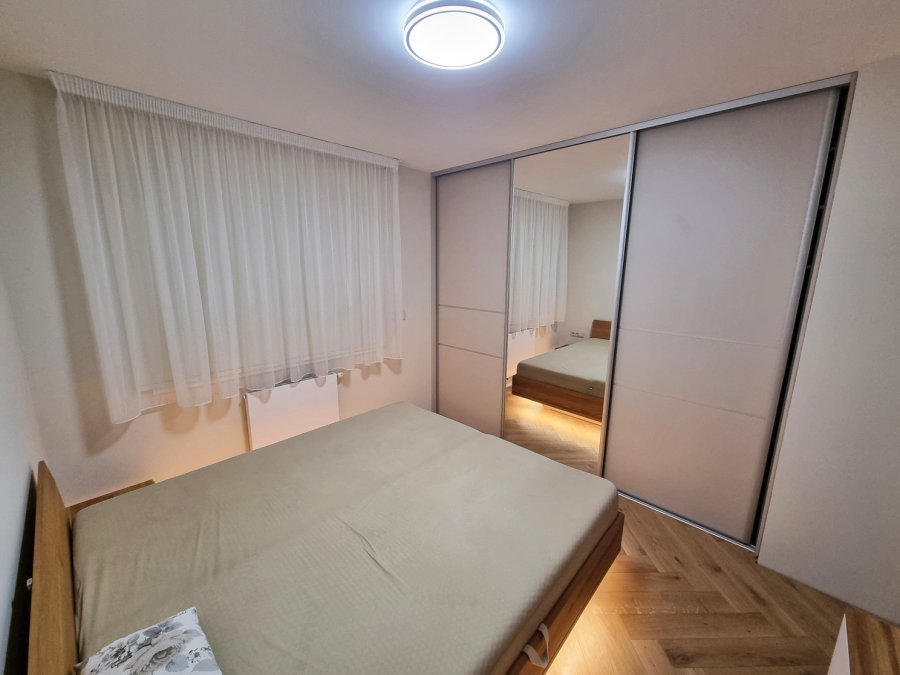 Ložnice s velkou vestavnou skříní se zrcadlem, dřevěnou postelí a jemným večerním osvětlením | Realizace interiéru byt Svitavy, Hradec Králové | Pemtrade.cz