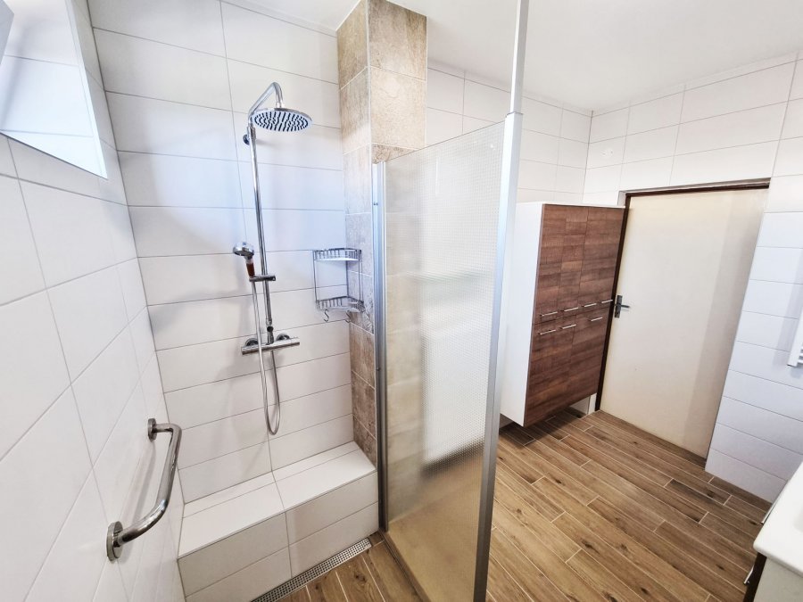 Pohled do koupelny s otevřeným sprchovým koutem a vysokou skříní Intedoor. Rekonstrukce interiérů, koupelen a kuchyní Svitavy, Hradec Králové | Pemtrade.cz.