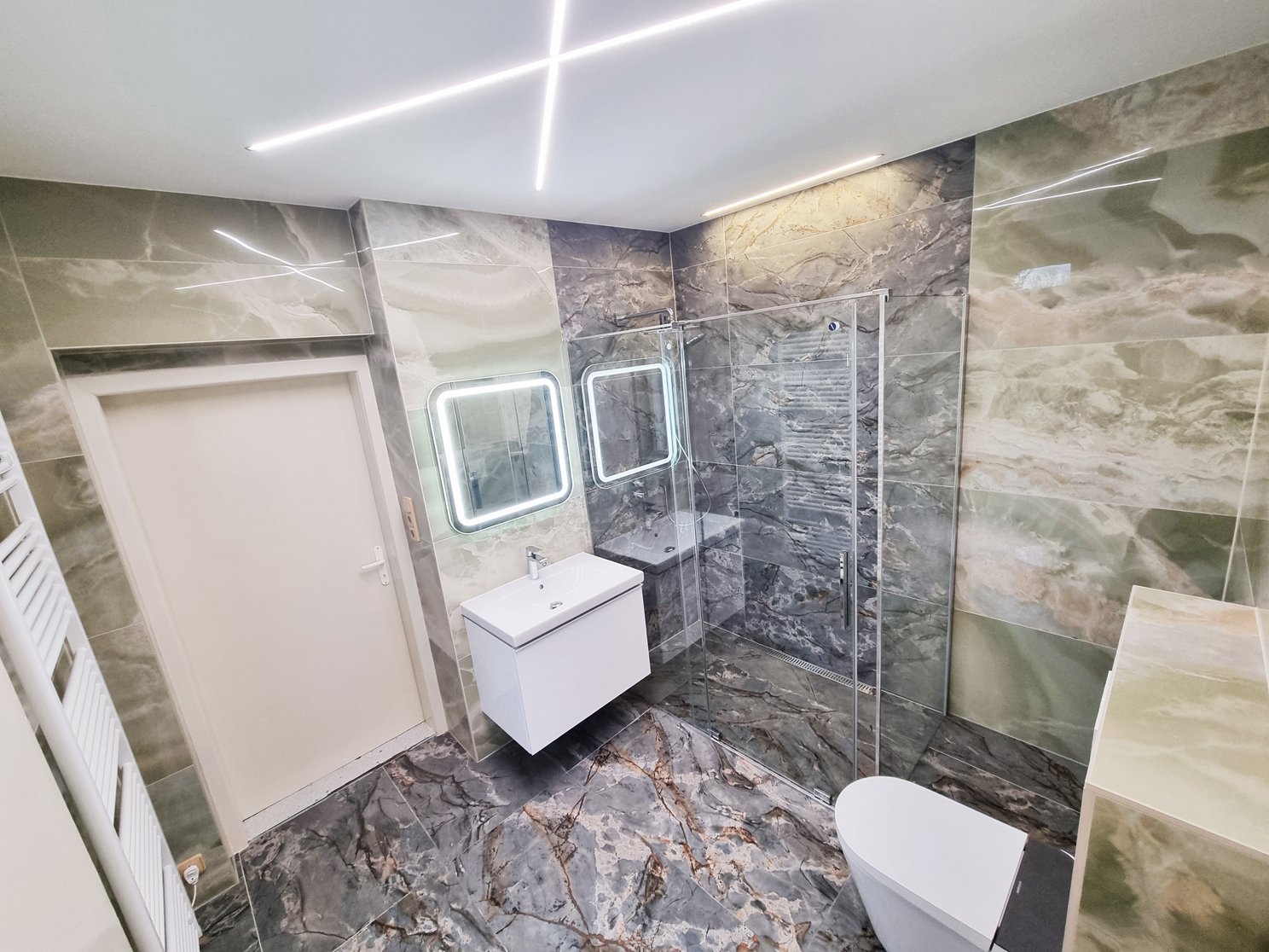 Celkový pohled na koupelnu se skleněnou stěnou RONAL, WC Watergate ADAPTA a radiátorem KORADO. Rekonstrukce koupelny, kuchyně a interiéru bytu Svitavy, Hradec Králové | Pemtrade.cz