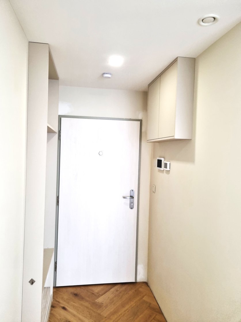 Vstupní chodba s úložnou skříní na míru, světlými dveřmi a dubovou podlahou do stromečku | Realizace interiéru byt Svitavy, Hradec Králové | Pemtrade.cz