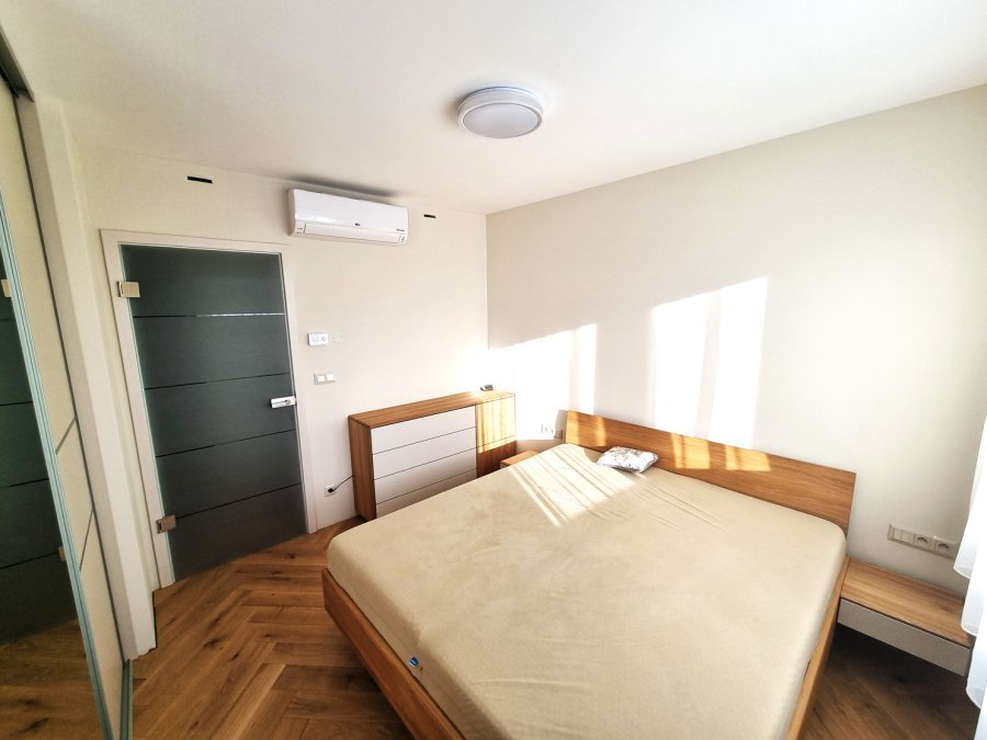 Světlá ložnice s dřevěnou postelí, dubovou podlahou a komodou v teplém dekoru dřeva | Realizace interiéru byt Svitavy, Hradec Králové | Pemtrade.cz