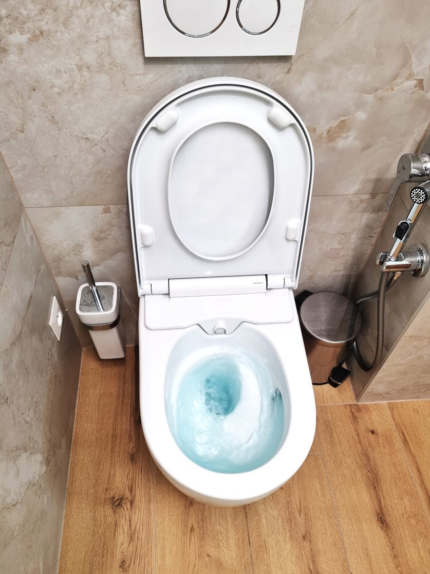 Závěsné WC Geberit AquaClean Sela v koupelně s obkladem v kamenném dekoru a podlahou v dekoru dřeva | Realizace koupelny Svitavy, Hradec Králové | Pemtrade.cz