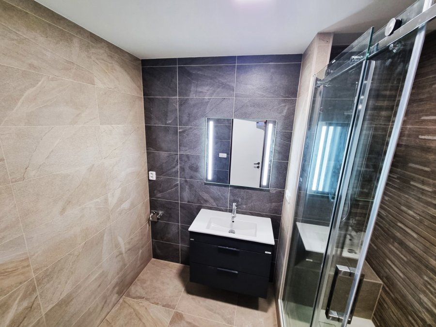 Koupelna se sprchovým koutem, kombinací tmavého obkladu a strukturovaného dekoru dřeva. Realizace koupelny, kuchyně a interiéru byt Svitavy, Hradec Králové | Pemtrade.cz