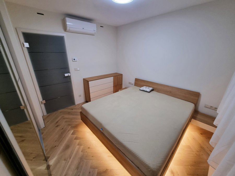 Večerní pohled na ložnici s dřevěným nábytkem, klimatizací a dubovou podlahou do stromečku | Realizace interiéru byt Svitavy, Hradec Králové | Pemtrade.cz