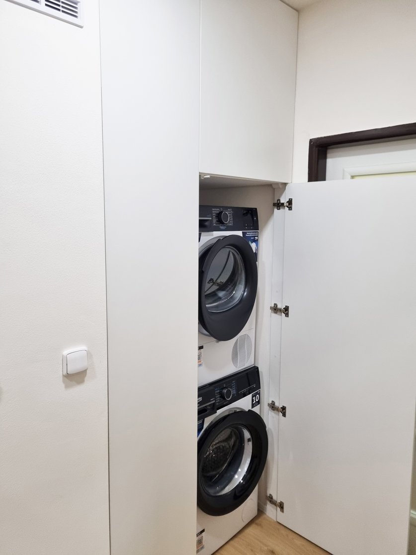 Vestavná skříň s pračkou a sušičkou nad sebou ve vstupní části bytu. Rekonstrukce koupelny, kuchyně a interiéru bytu Svitavy, Hradec Králové | Pemtrade.cz