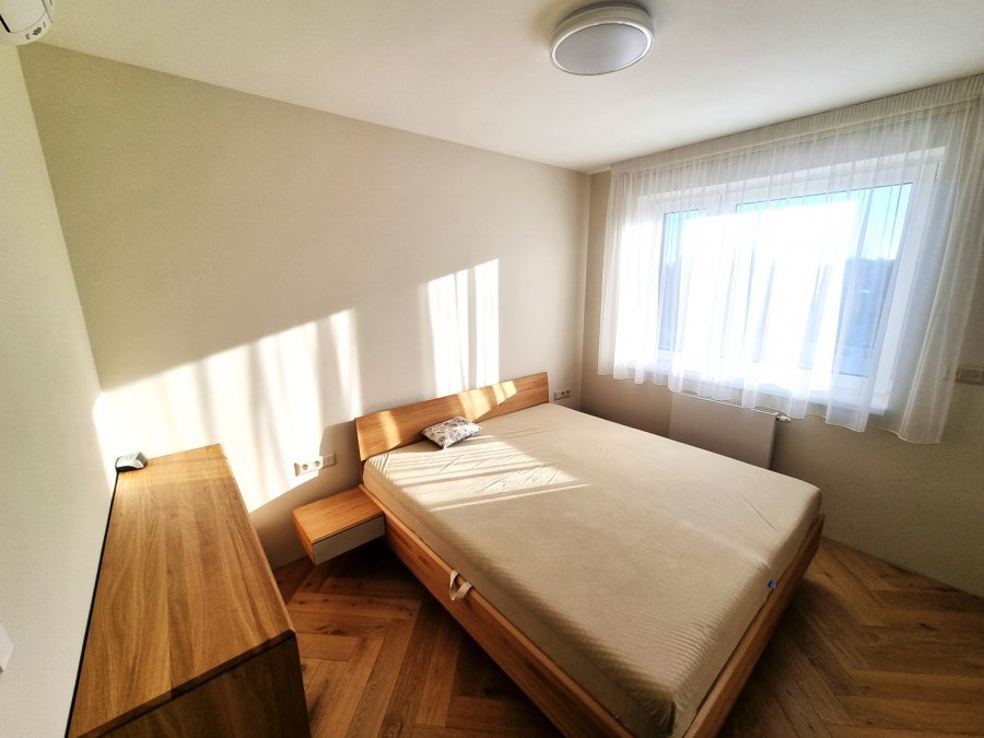 Ložnice s dřevěnou postelí, komodou a dubovou podlahou v klidném přírodním ladění | Realizace interiéru byt Svitavy, Hradec Králové | Pemtrade.cz