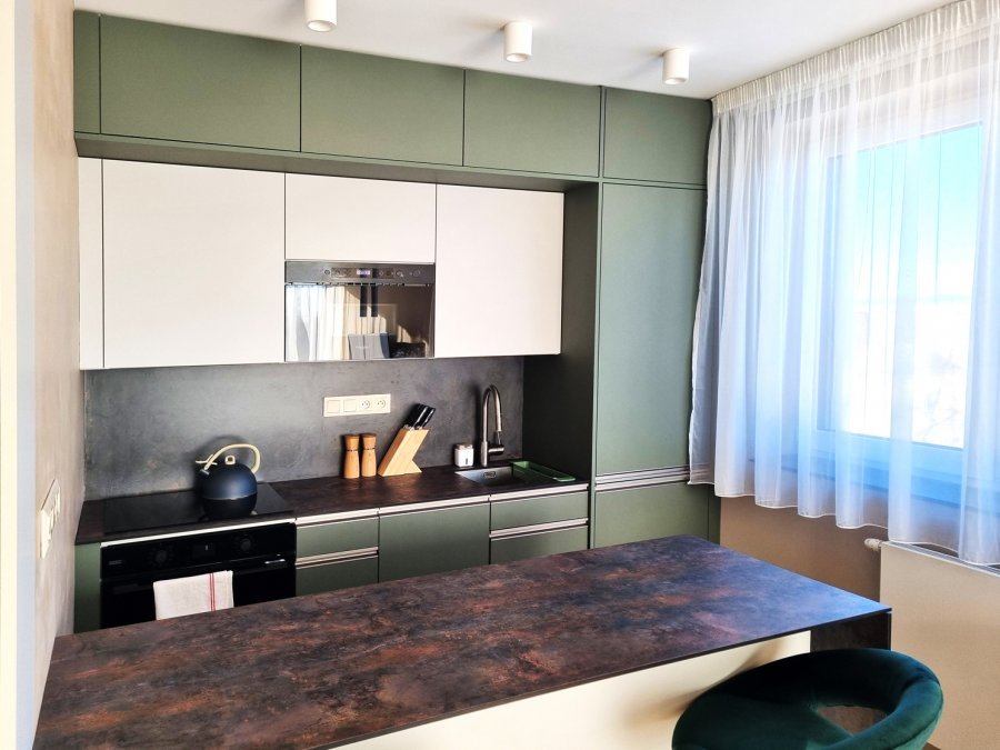 Detail olivově zelené kuchyňské linky s tmavou pracovní deskou, bílými horními skříňkami a vestavnými spotřebiči Whirlpool | Realizace kuchyně a interiéru byt Svitavy, Hradec Králové | Pemtrade.cz