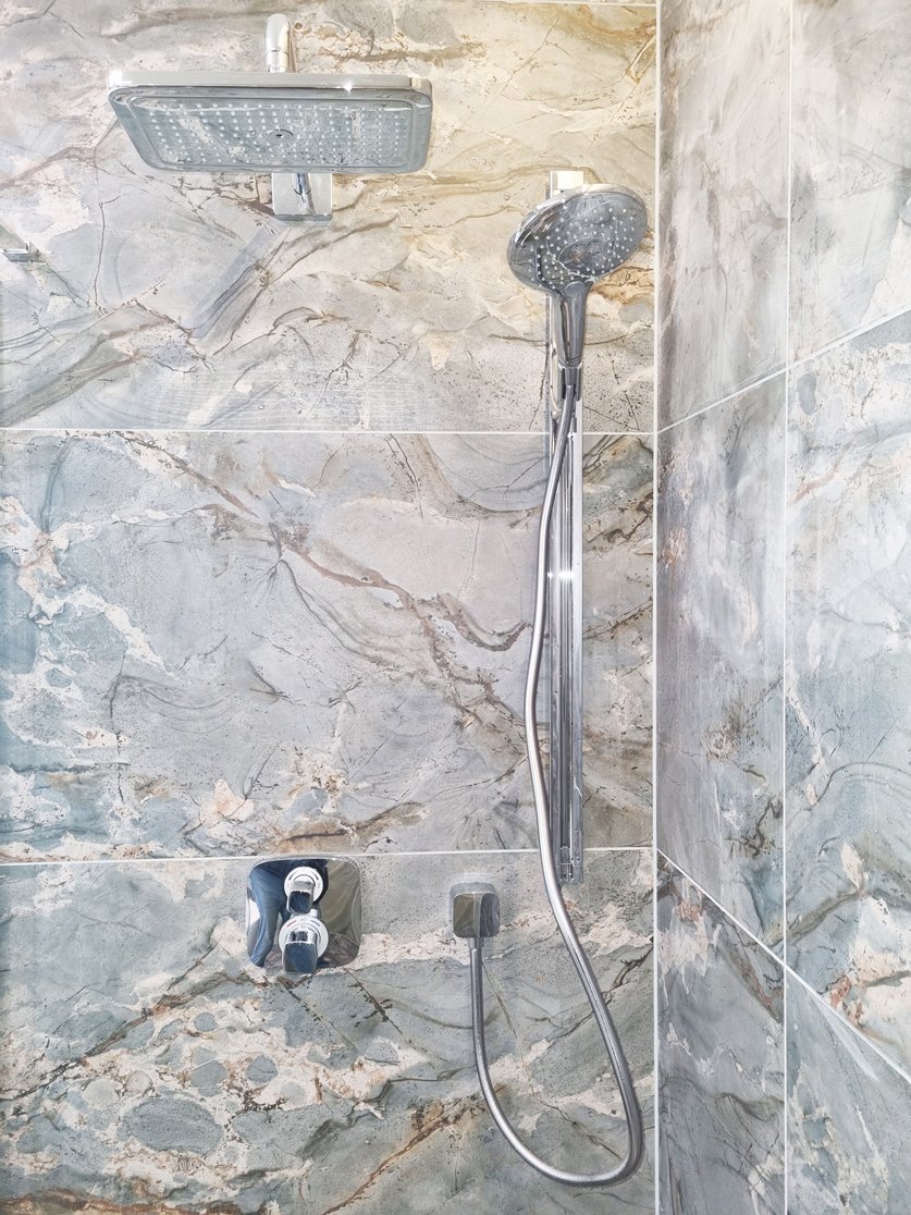 Detail sprchy Hansgrohe Raindance s hlavicí Croma E 280 a podomítkovou baterií Ecostat E v mramorovém obkladu. Rekonstrukce koupelny, kuchyně a interiéru bytu Svitavy, Hradec Králové | Pemtrade.cz