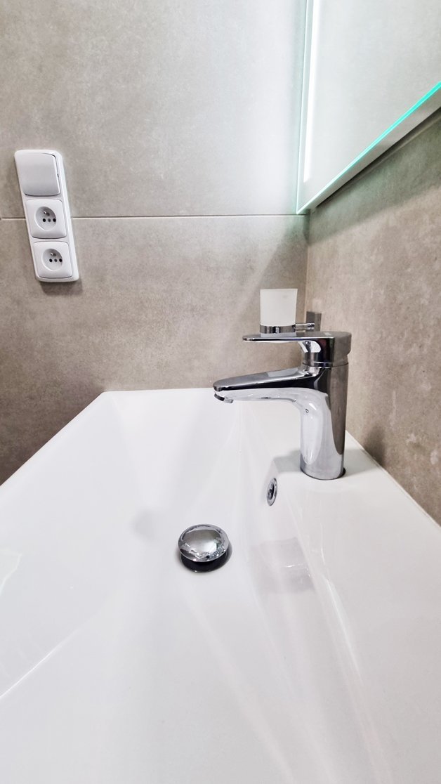 Detail umyvadlové baterie HERZ INFINITY a keramického umyvadla s chromovými doplňky. Rekonstrukce koupelny, kuchyně a interiéru bytu Svitavy, Hradec Králové | Pemtrade.cz