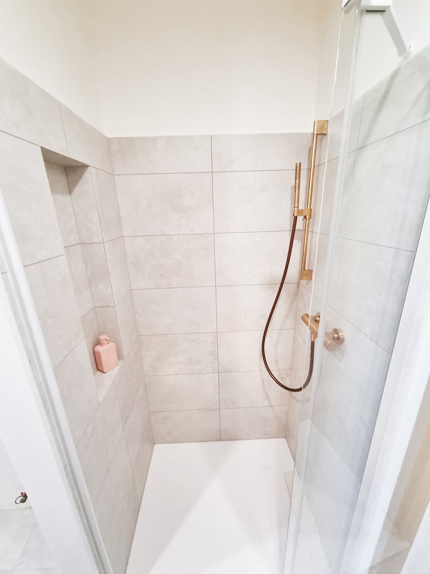 Detail sprchové tyče a ruční sprchy RAVAK v provedení Rose Gold Brushed. Rekonstrukce koupelny, kuchyně a interiérů bytu Svitavy, Hradec Králové | Pemtrade.cz