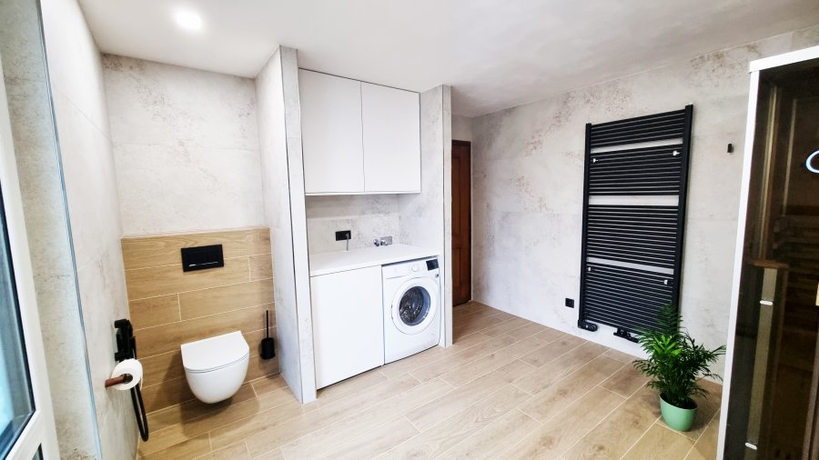 Pohled na koupelnu s WC JIKA MIO-N, pračkou a bílou vestavěnou skříní. Celou koupelnu krásně doplňuje designový černý otopný žebřík KORADO KORALUX Linear Max. Rekonstrukce koupelny a interiéru bytu Svitavy, Hradec Králové | Pemtrade.cz