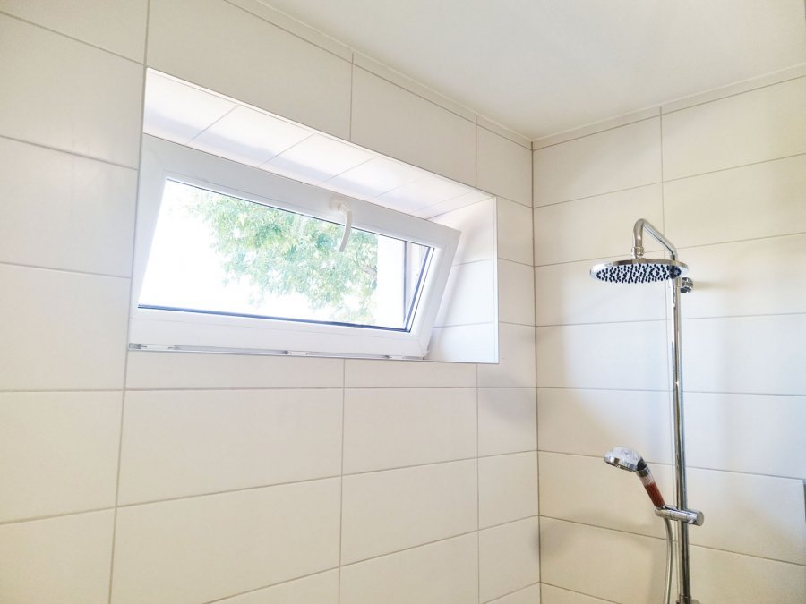 Horní část sprchového koutu s otevřeným oknem a bílým obkladem. Rekonstrukce interiérů, koupelen a kuchyní Svitavy, Hradec Králové | Pemtrade.cz.