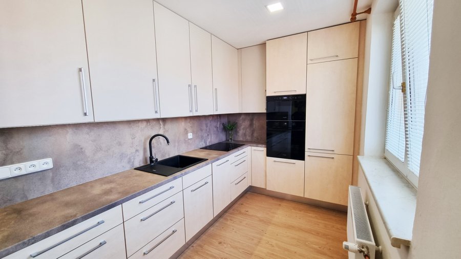 Kuchyňská linka s betonovým dekorem pracovní plochy a obkladu, černým dřezem a bílými horními skříňkami, vestavné spotřebiče Whirlpool. Rekonstrukce koupelny, kuchyně a interiéru bytu Svitavy, Hradec Králové | Pemtrade.cz