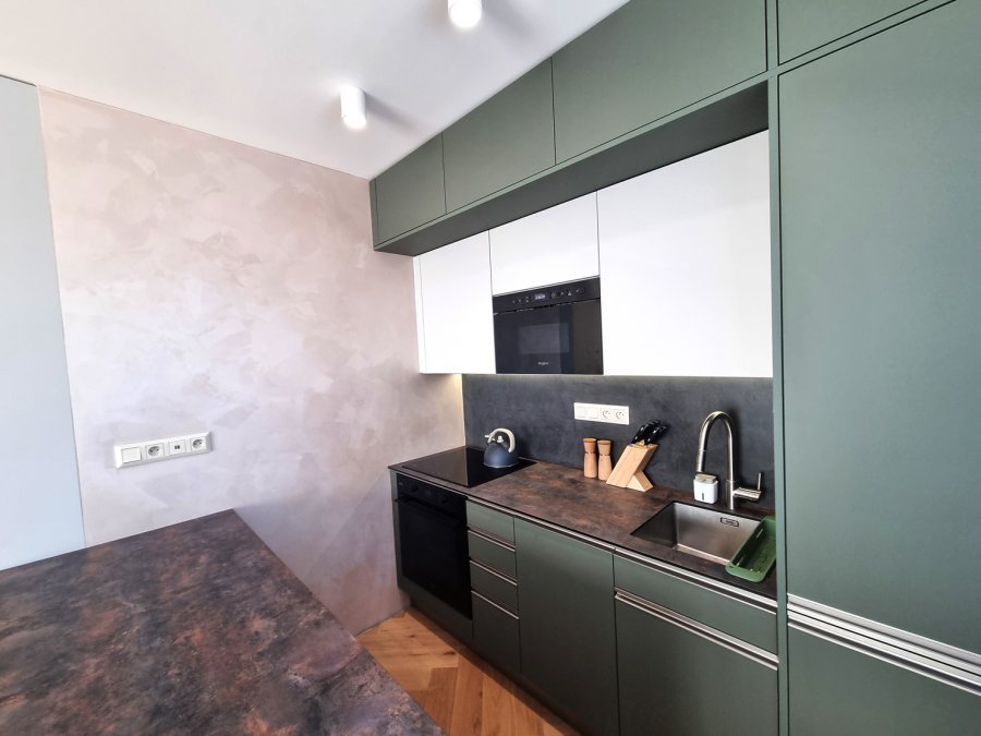 Kompaktní kuchyňská linka s tmavou pracovní deskou, olivově zelenými skříňkami a vestavnou troubou Whirlpool | Realizace kuchyně a interiéru byt Svitavy, Hradec Králové | Pemtrade.cz