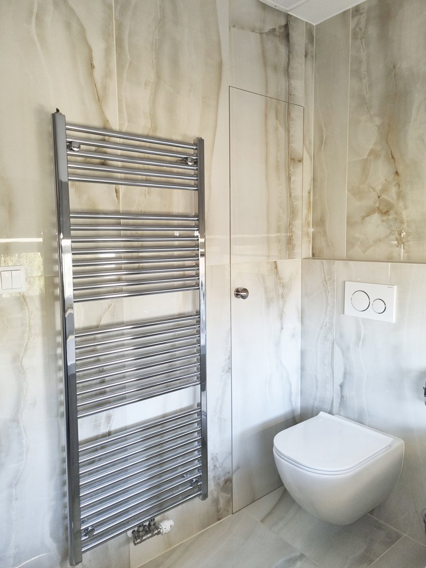 Detail radiátoru Korado Koralux Linear, závěsného WC a "tajných" dveří do komory – Rekonstrukce koupelny, kuchyně a interiéru bytu Svitavy, Hradec Králové | Pemtrade.cz
