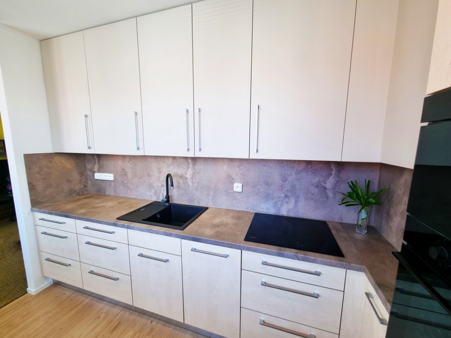 Kuchyňská linka s betonovým dekorem pracovní plochy a obkladu, černým dřezem a bílými horními skříňkami, vestavné spotřebiče Whirlpool. Rekonstrukce koupelny, kuchyně a interiéru bytu Svitavy, Hradec Králové | Pemtrade.cz